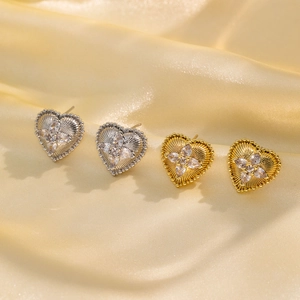 Eleganti orecchini a cuore in oro e argento con zirconi su lussuoso sfondo di raso