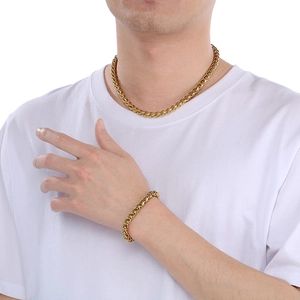 Dettaglio di un set da uomo con collana e bracciale a catena intrecciata placcata oro