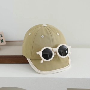 Détail d'une casquette bébé kaki avec bordure blanche et lunettes de soleil intégrées