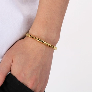 Gros plan d'un bracelet en chaîne box dorée avec fermoir magnétique sur le poignet
