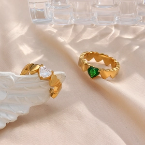18K gold plated heart rings with white and green zircons on beige silk fabric background