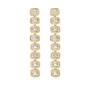 Detail of long gold-plated drop earrings featuring sparkling rectangular zircon stones
