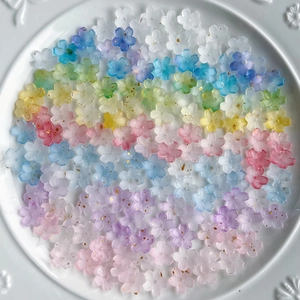 Macro detail of gradient flower resin beads with gold flakes in a white ceramic dish