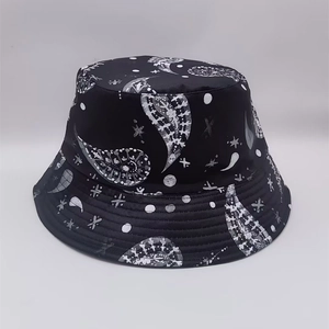Detailed view of the black bucket hat with white abstract prints and reinforced stitching