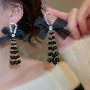 Detail view of elegant black bow tassel earrings with micro-inlaid rhinestones