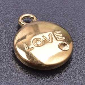 Macro shot of circular gold LOVE pendant accessory with 18k plating for DIY necklace