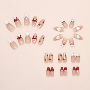 Macro shot of press-on nails featuring red bows, white polka dots, and star designs