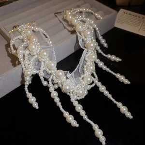 Detailed close-up of beaded pearl lace fringe necklace on velvet jewelry display