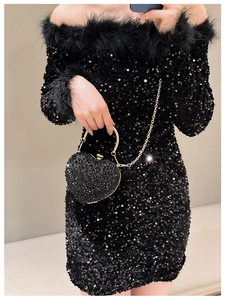 Detail of heart-shaped rhinestone evening bag with gold handle and chain strap