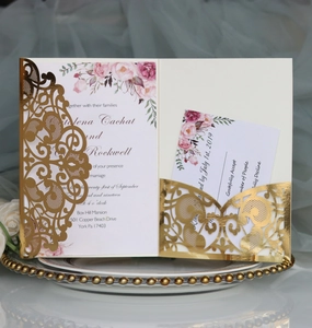 Detail of laser-cut gold wedding invitation suite with elegant floral inner cards