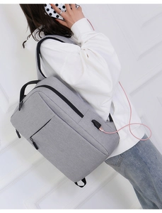 Side view of grey laptop backpack with integrated USB port and external charging cable