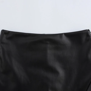 Detailed close-up showing the fine texture of black PU leather on minimalist shorts