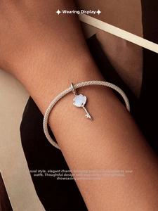 Détail d'un bracelet en maille d'argent 925 avec pendentif clé nuage incrusté de nacre