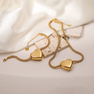 Elegant 18K gold-plated heart pendant necklace and bracelet set on a woven mesh chain