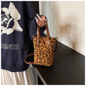 Close-up of leopard print mini crossbody bag with a suede texture and brown handle