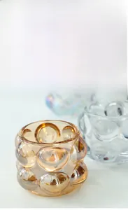 Macro di un portacandele in vetro a bolle ambra che mostra la consistenza artigianale