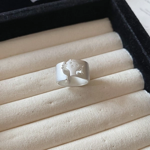 Detail showing the matte silver cat-shaped open ring with a brushed metal texture finish