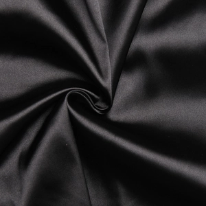 Detailaufnahme von elegantem schwarzem Satinstoff mit weichen Falten und seidiger Textur