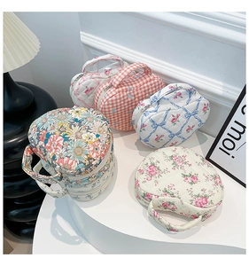 Collection of floral quilted heart shaped cosmetic bags with top handles and zippers