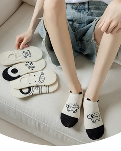 Close-up of cute cartoon dog patterns on beige cotton no-show socks for women