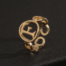 Macro view of gold-tone evil eye ring with chain-link band and adjustable opening