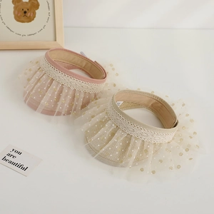 Detail showing lace edges and polka dot mesh on these woven sun visors for kids