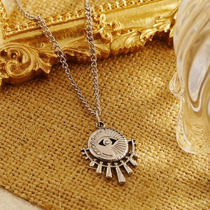 Silver evil eye sun pendant necklace with moon crescents on rustic linen backdrop