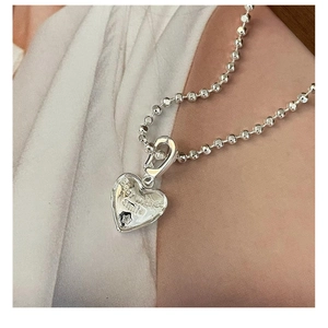 Macro detail of S925 silver heart pendant engraved with Best Wishes Smile and stars