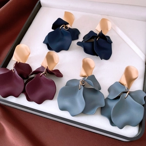Three pairs of matte acrylic petal earrings in blue and red on premium silk background