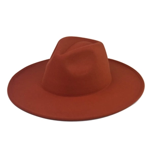 Detail view of brick red wool fedora featuring flat wide brim and classic crown design