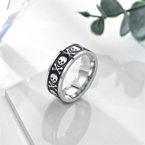 Macro view of wide stainless steel skull ring with vintage black relief details