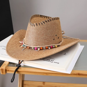 Detail of western straw cowboy hat with colorful beads, shells and feather charms decor