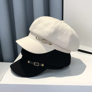 Classic British style newsboy caps in black and white with metal buckle details