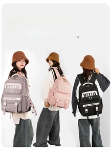 Three large capacity student backpacks in dark grey, pink and black with multiple pockets