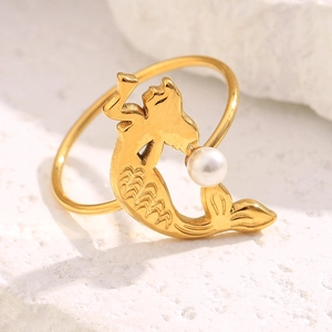 Macro shot of 18K gold plated mermaid ring with white pearl on white stone texture