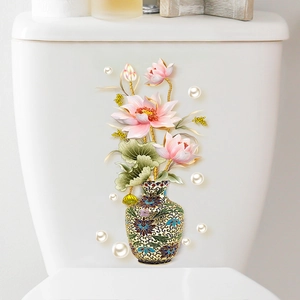 Dettaglio di un adesivo floreale con loto e vaso blu su una cassetta del WC in ceramica bianca