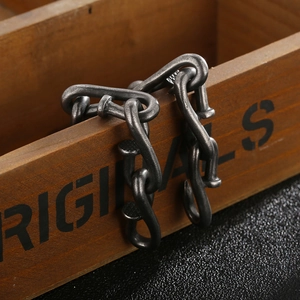 Detail of vintage industrial steel chain bracelet on a rustic wood box with leather texture
