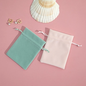 Detail of plush velvet drawstring jewelry pouches in mint green and light pink colors