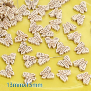 Detailed view of 13mmx15mm cream butterfly beads with vintage brown texture for DIY jewelry