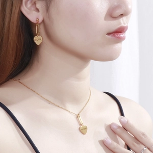 Golden MOM heart jewelry set including earrings and necklace on a female model
