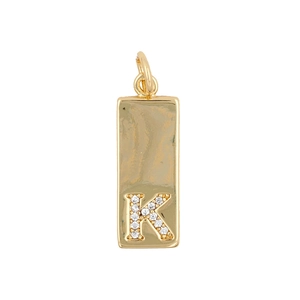 Macro detail of a gold rectangular pendant featuring a zircon-studded letter K design