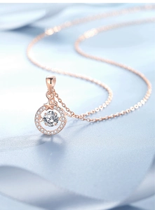 Macro shot of rose gold star pendant necklace with sparkling moissanite and claw setting