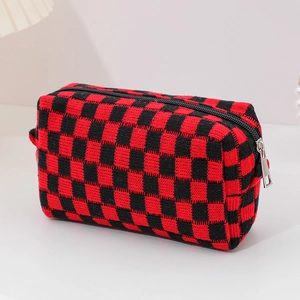 Detail of red and black checkered knit makeup bag featuring a durable black zipper