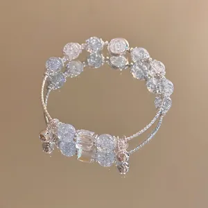 Detail view of crystal beaded butterfly bracelet with bells on a gold mirror surface