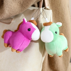 Detail of plush pony charms in purple and green on a canvas bag with silver bead chains