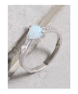 Dettaglio macro di un anello in argento S925 con opale a cuore e superficie testurizzata