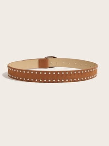 Détail de la ceinture en daim marron avec rivets argentés à double rangée et boucle