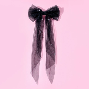 Detail of a large black mesh bow hair clip featuring elegant white pearls and long ribbons
