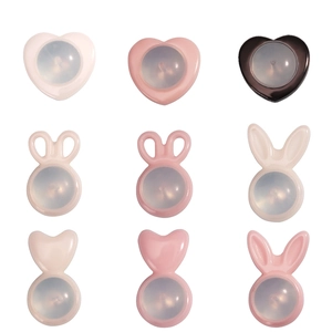 Macro view of heart and rabbit ear shaped pink ceramic earring backs in a neat grid