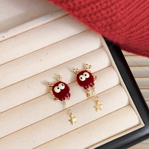 Détails de boucles d'oreilles nœuds velours avec bois dorés dans un écrin beige